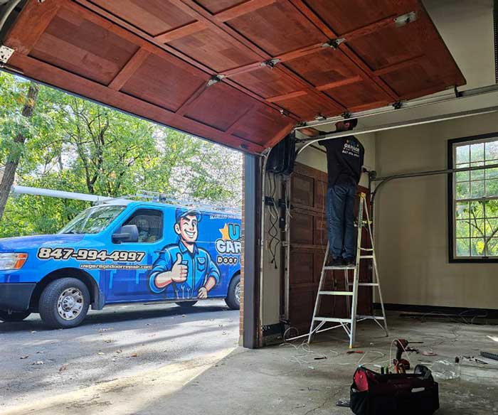 A US Garage Door Repair tech fixing garage door near Arlington Heights IL