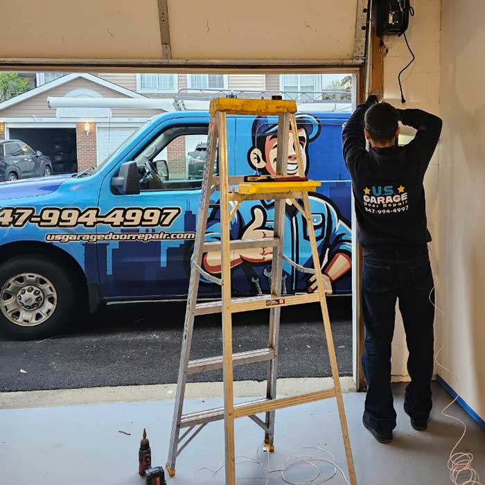 Professional Garage Door Repair & Installation Services Near Lake Zurich IL Our US Garage Door Repair technician fixing garage door in Lake Zurich, IL and our work truck is in the background