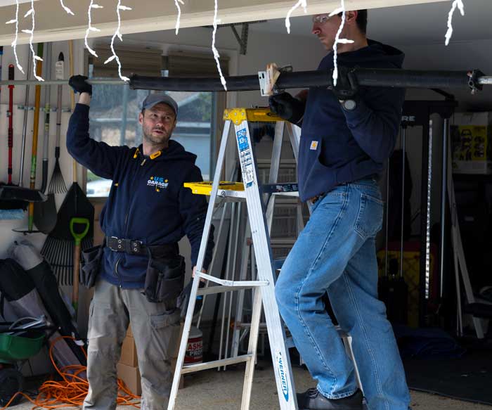 US Garage Door Repair technicians fixing a broken garage door spring near Gurnee, IL